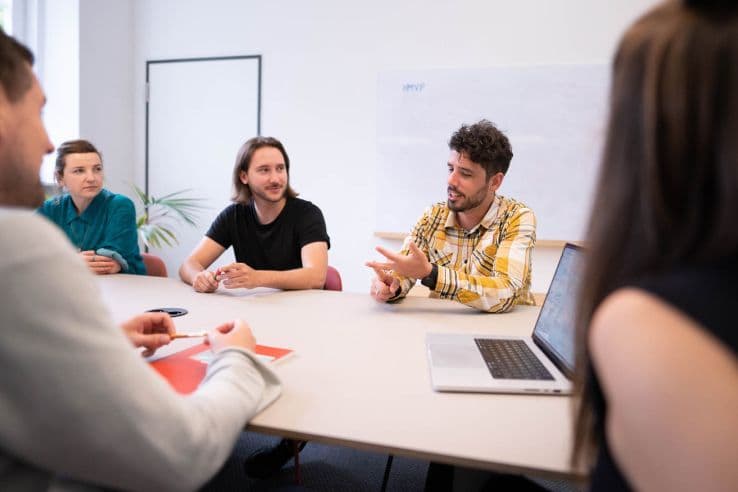 Personen an einem Tisch diskutieren 