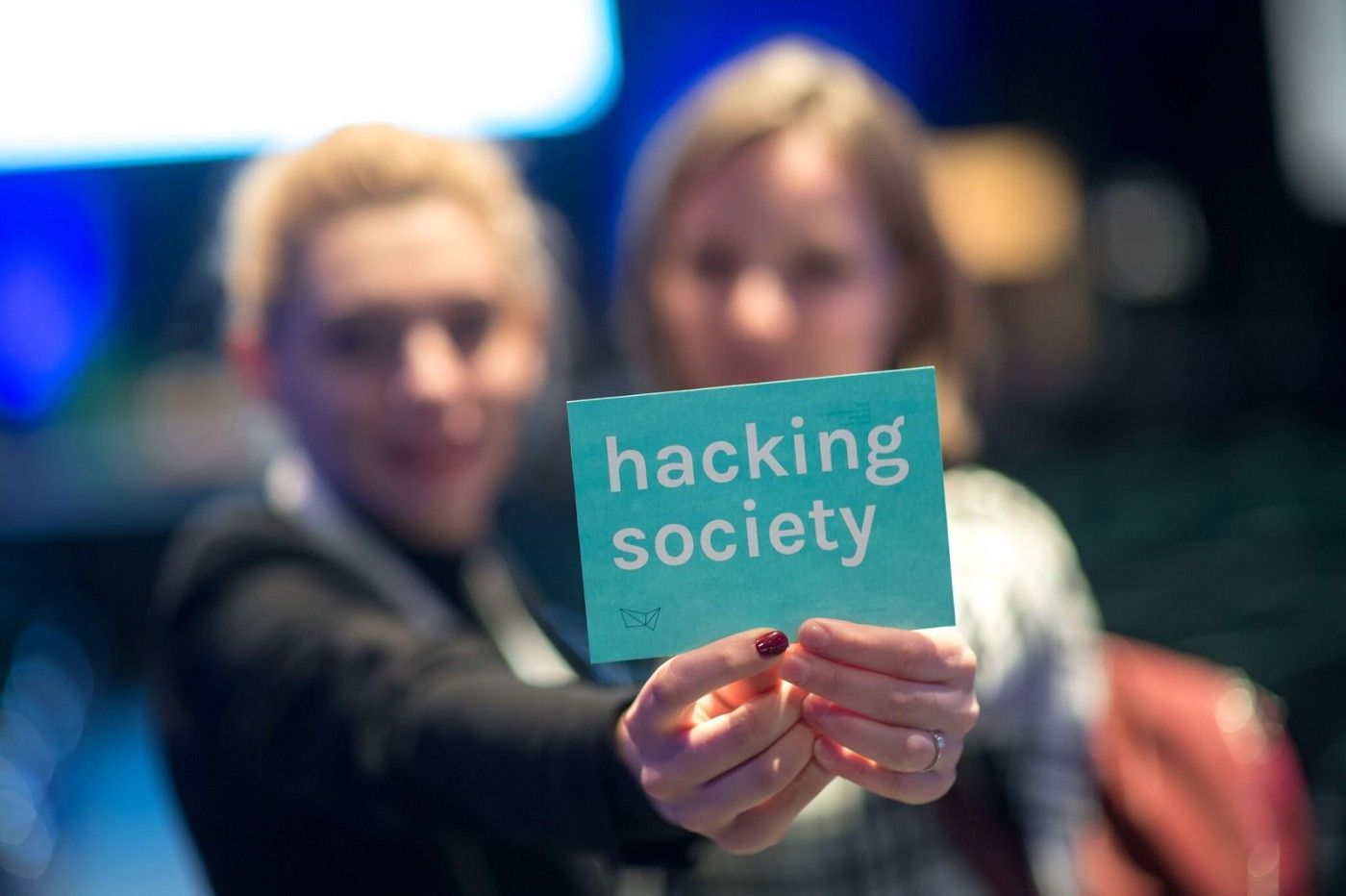 people holding card with slogan: hack society